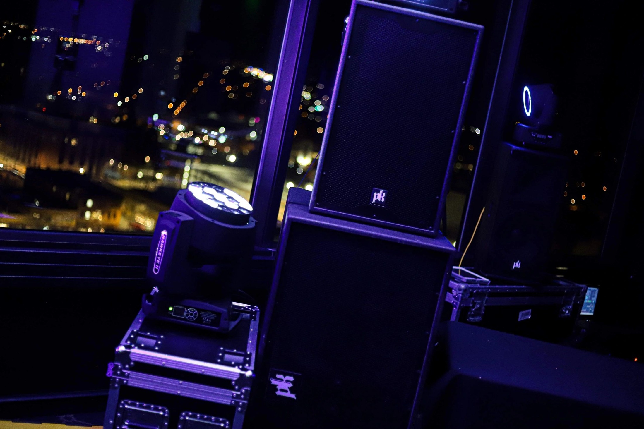 PK Sound tops and a moving light set up above the city at night